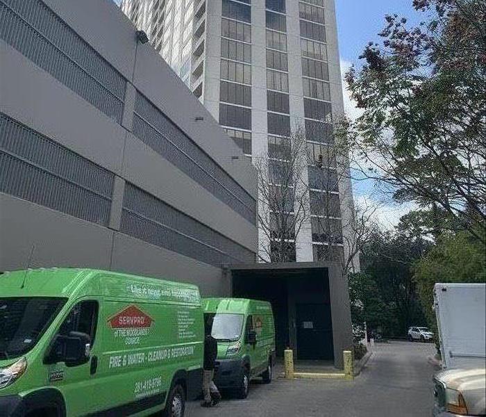 SERVPRO cars parked outside a high-rise. 