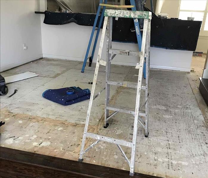 A restoration with ladders on a kitchen/dining room taking process 