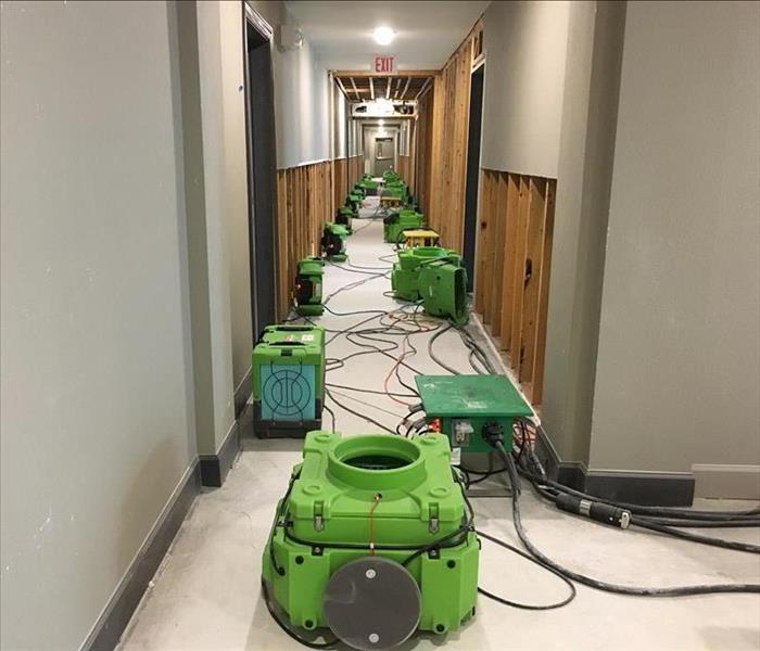 Many air movers set up in hallway.